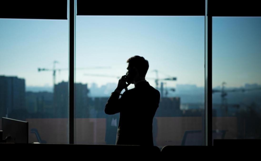 Student working on video editing project with instructor reviewing timeline and providing feedback